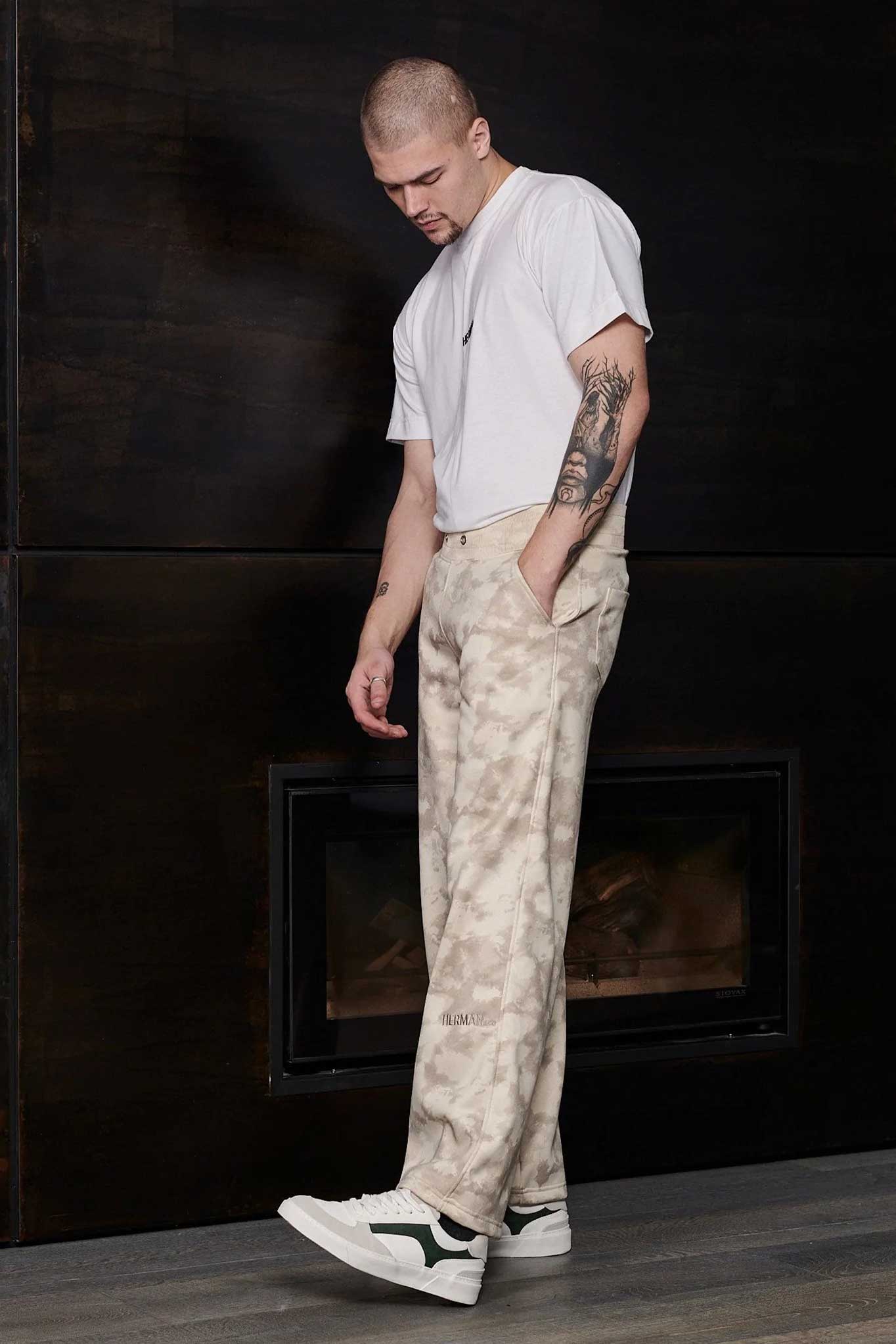 Model wearing mens beige tie dye joggers in a relaxed streetwear outfit