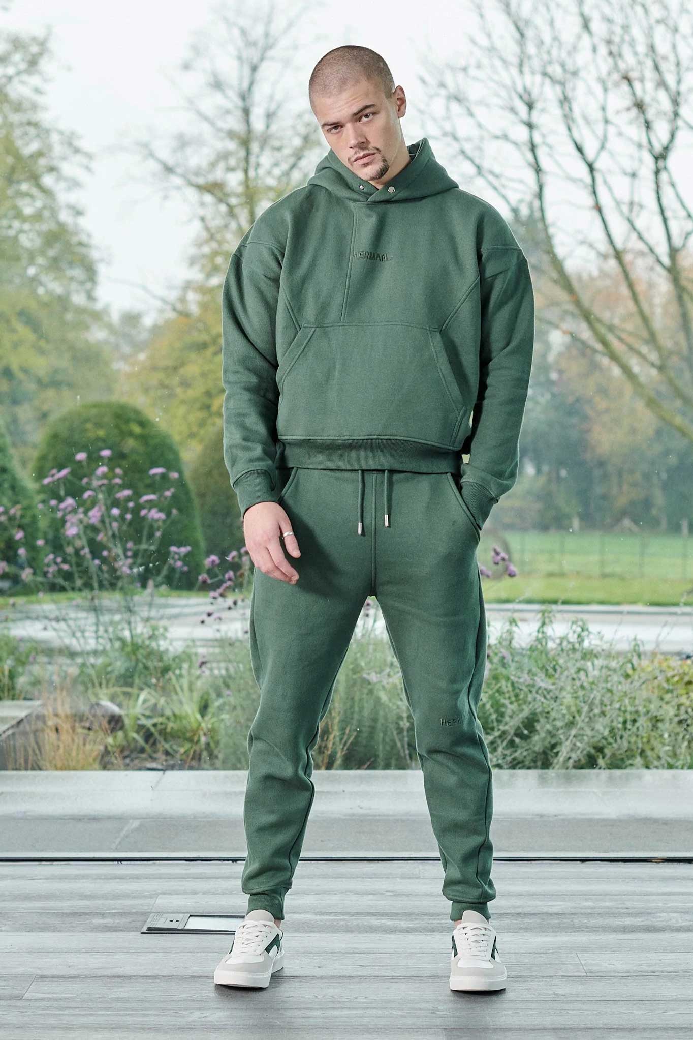 Front view of model wearing mens dark green hoodie with matching joggers