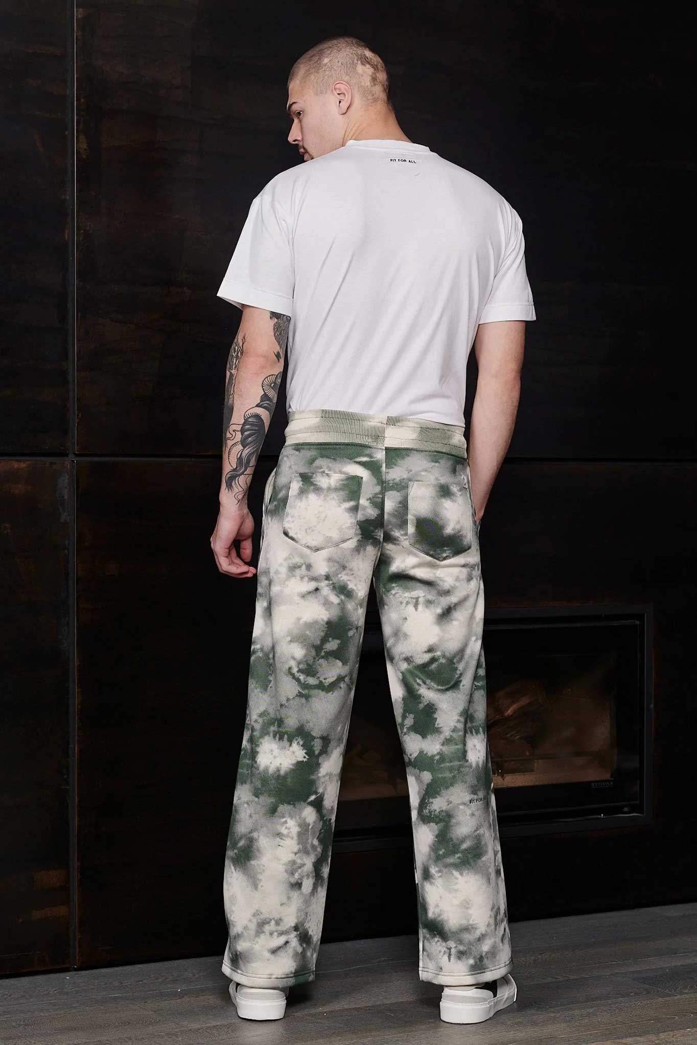 Back view of a model wearing the men's green tie-dye joggers.