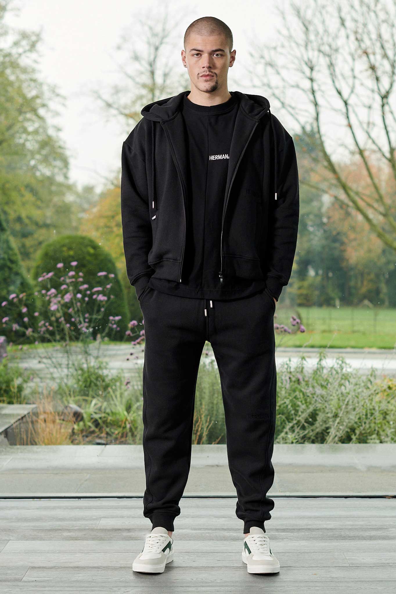 A model styled in the tapered joggers for men with a matching black zip hoodie