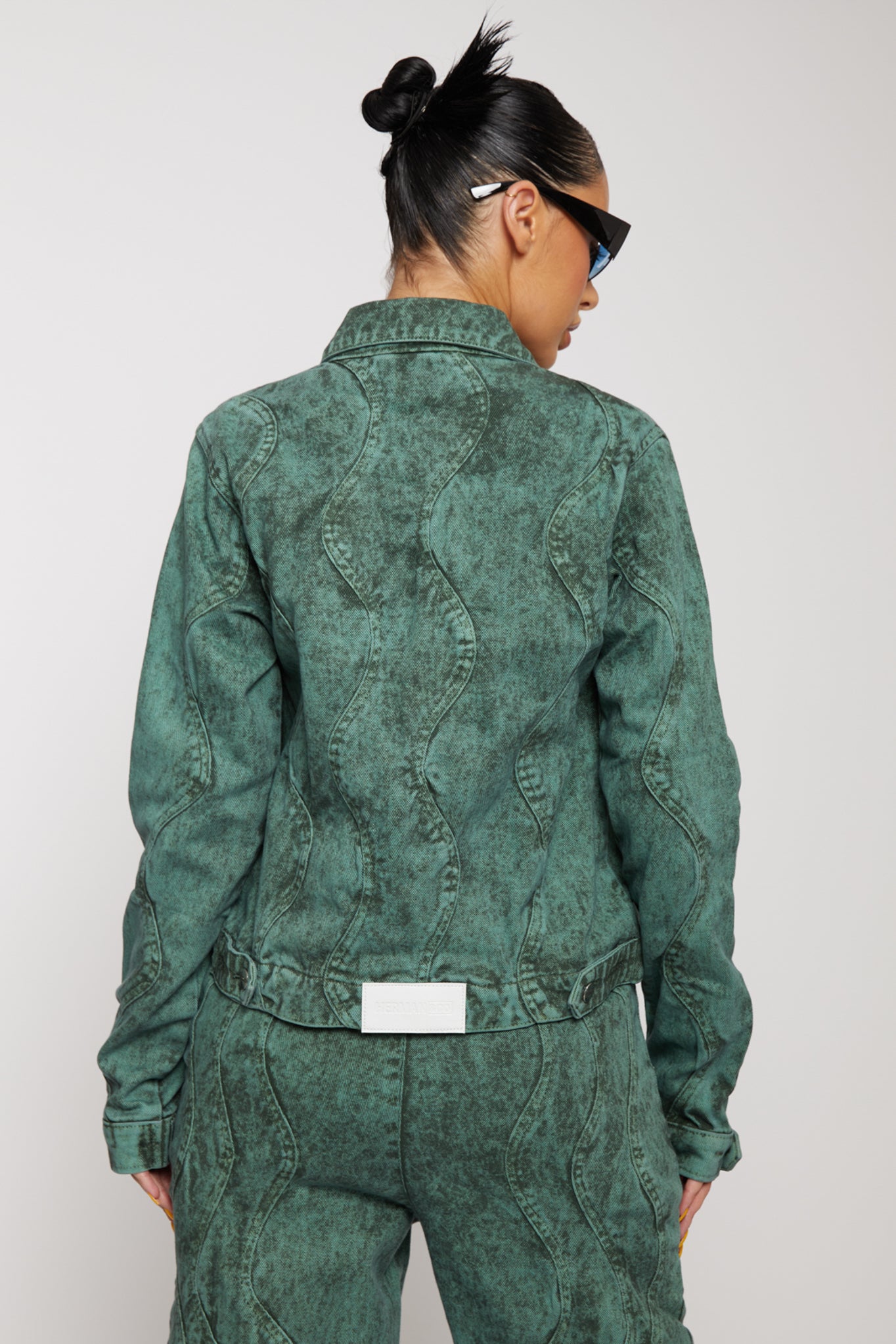 Close-up of the wavy pattern on the back of the green denim jacket