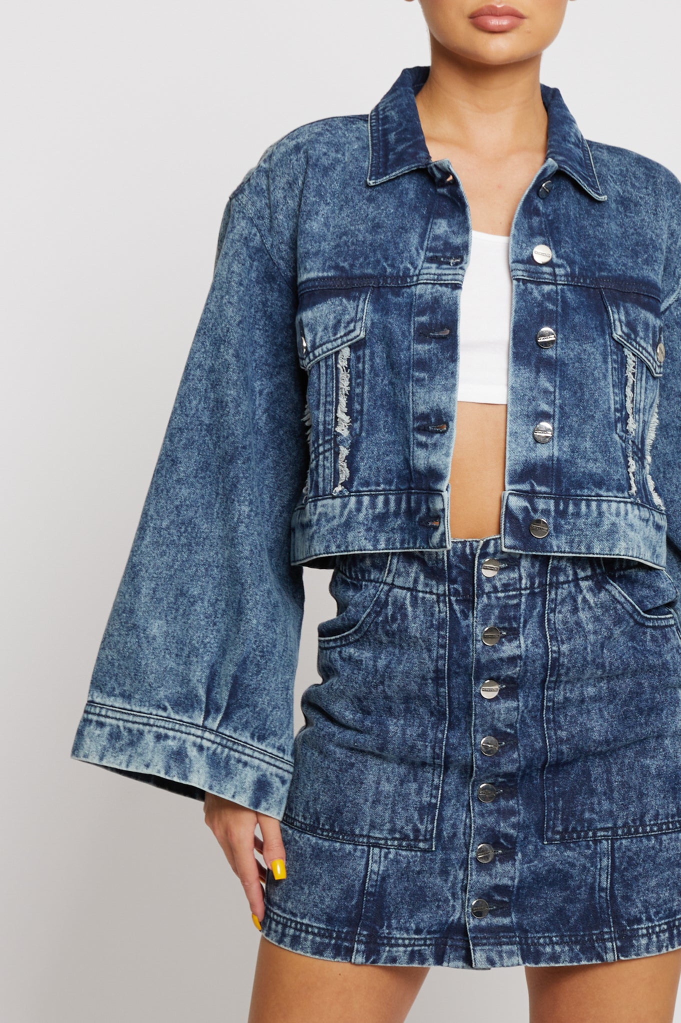 Close-up of the wide, flared sleeve on the acid wash denim jacket.