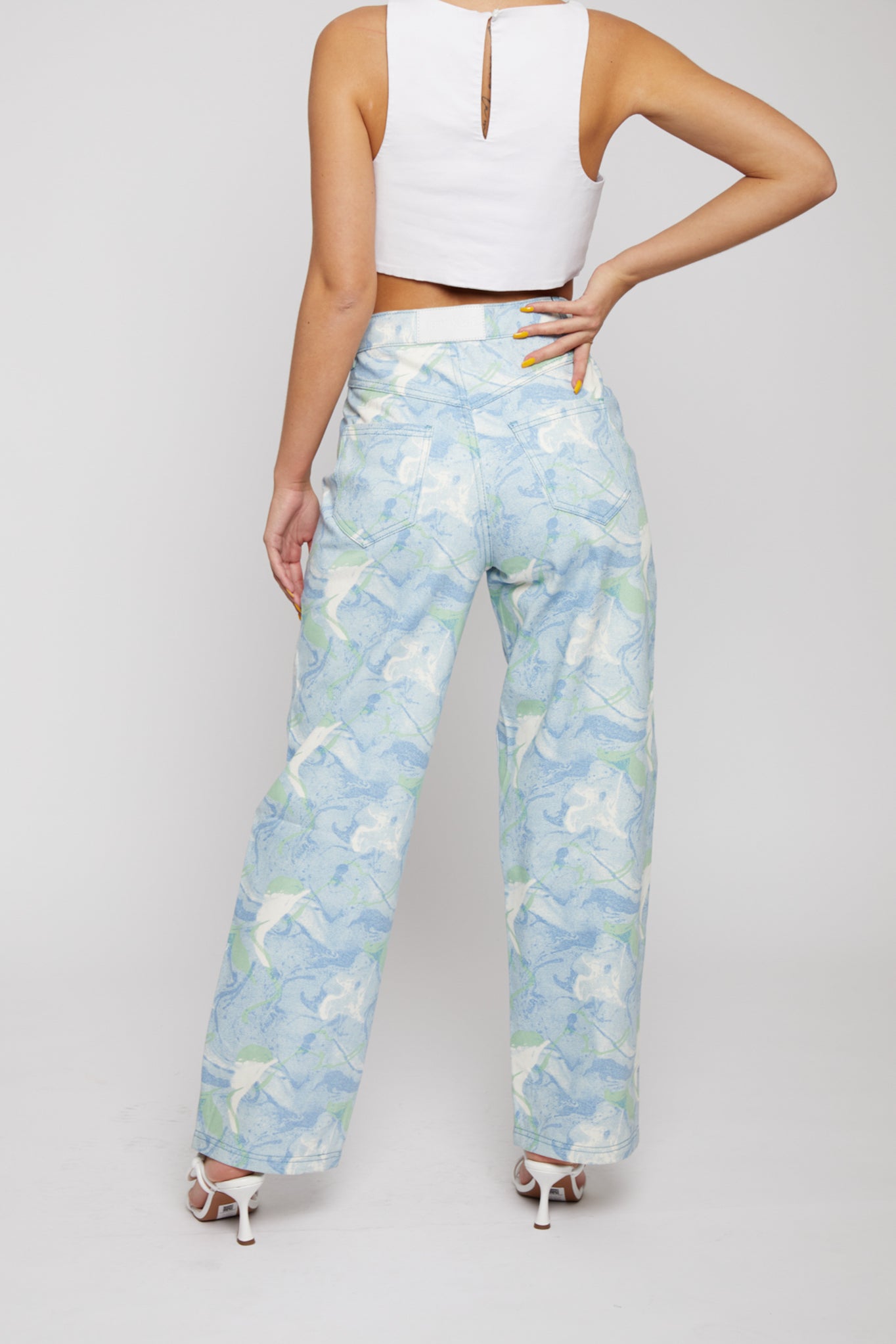 Angled back view of a model wearing the women's psychedelic jeans.