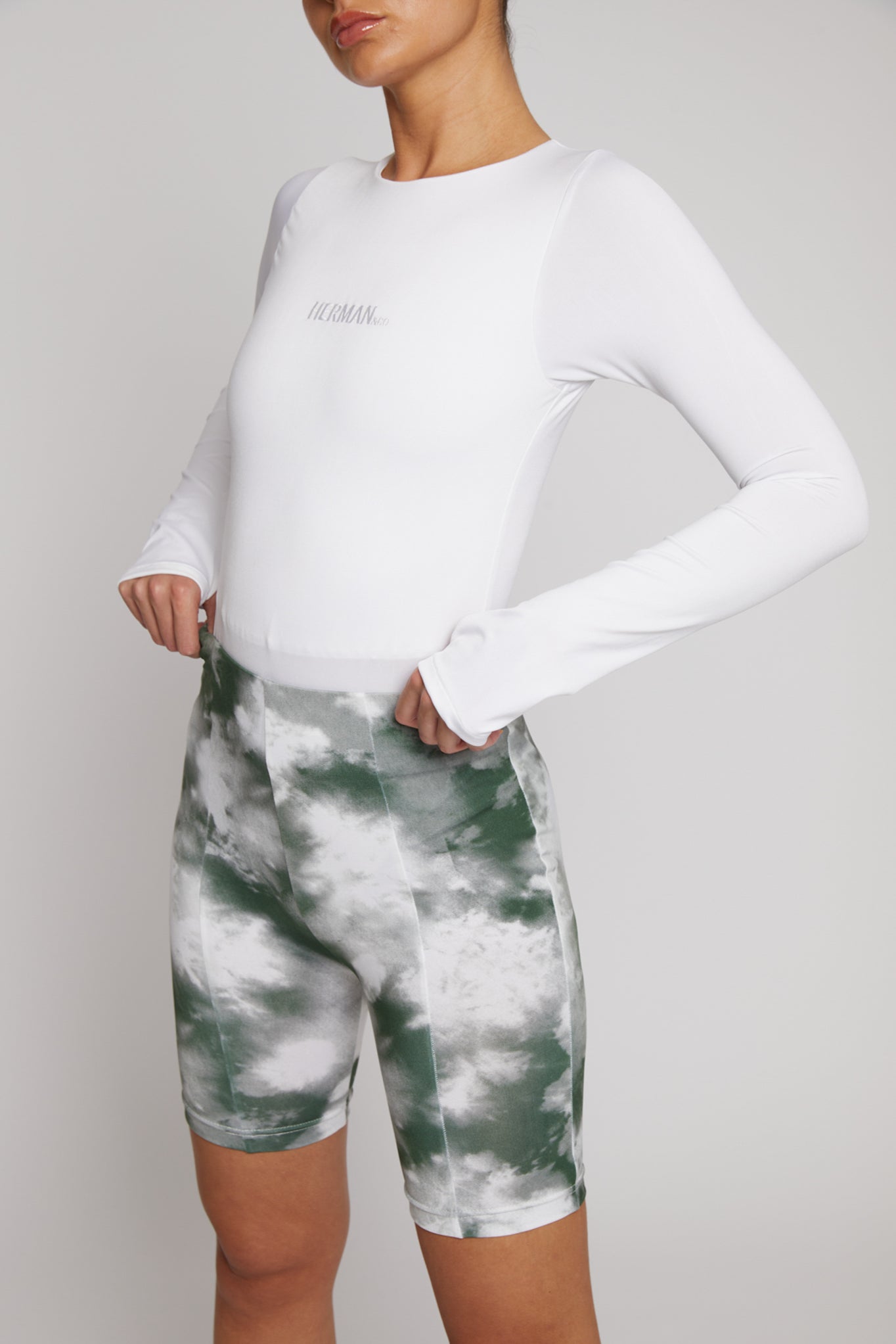 Front close-up of a woman wearing the white long-sleeve bodysuit.