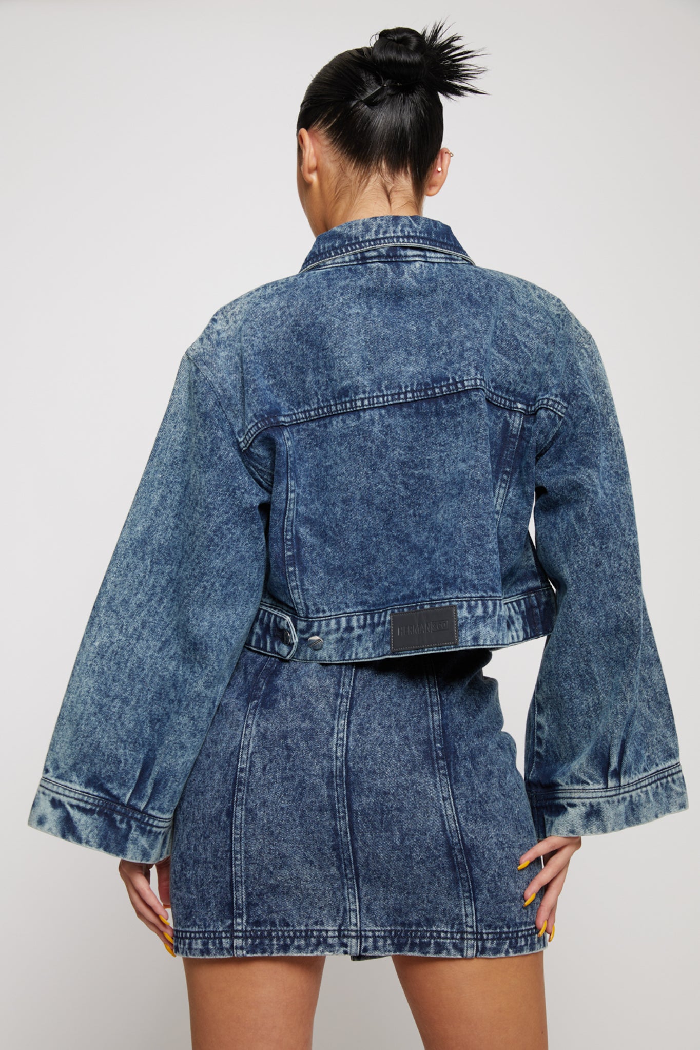 Close-up of the back and flared sleeves on the women's acid wash denim set.