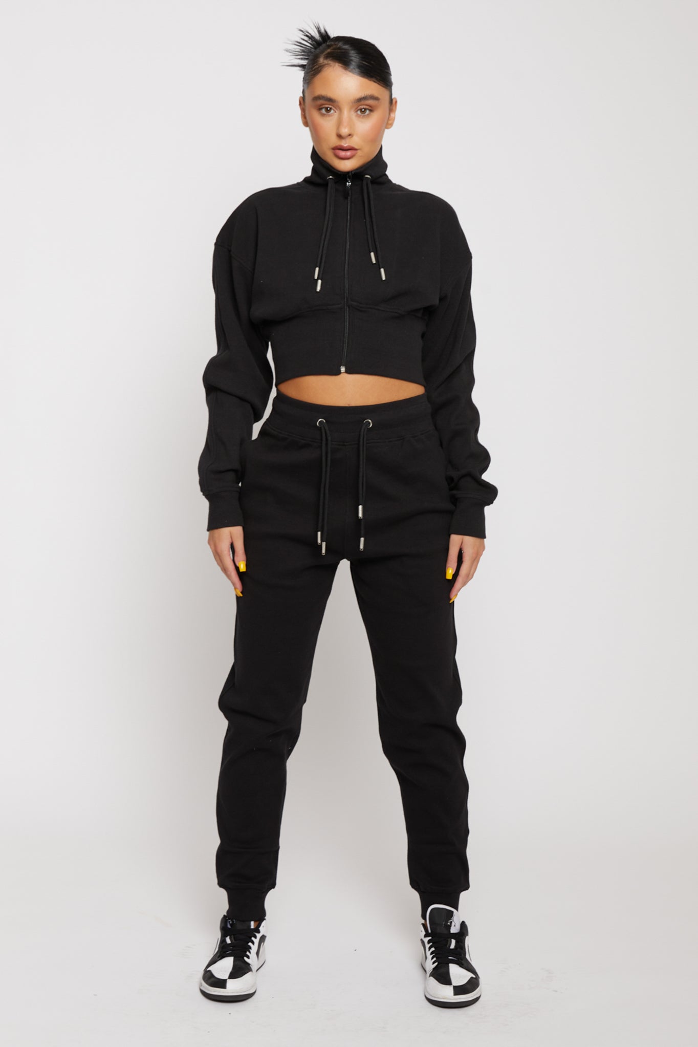 Front view of model wearing black zip neck sweatshirt women outfit with joggers