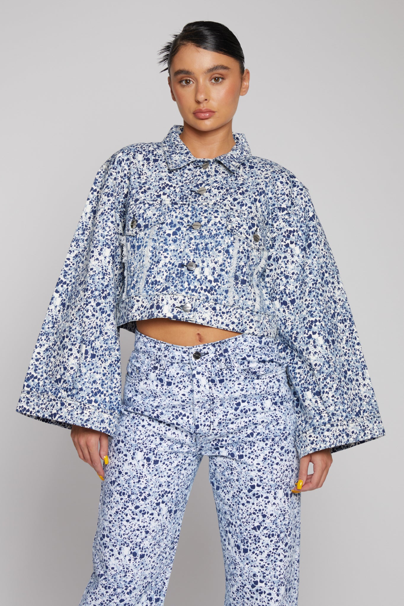 Front close-up of the women's blue marble print crop denim jacket.