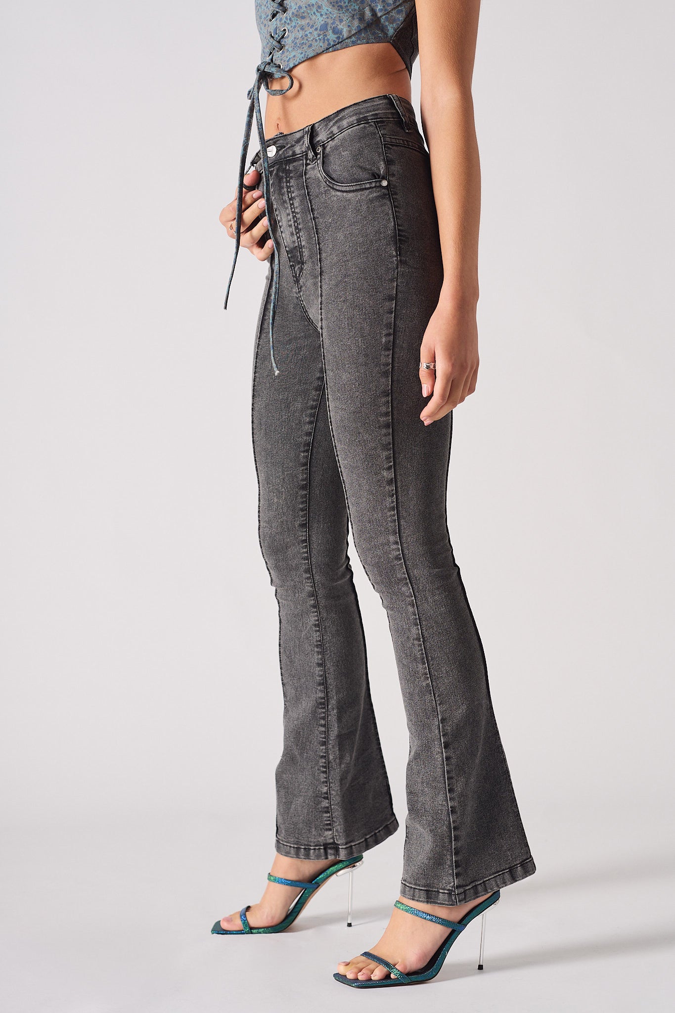 Angled view showing the flare on the acid grey jeans for women.