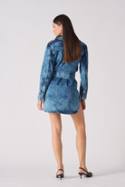 Back view of a model in the acid wash denim dress, showing the popper belt