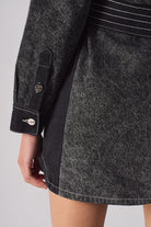 Close-up showing the sleeve cuff and dark side panel on the acid wash denim dress