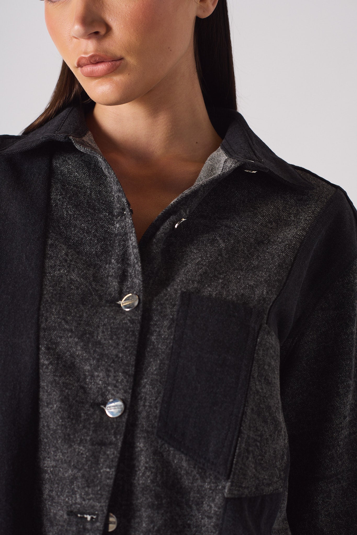 Close-up of the collar and pocket detail on the acid wash denim shirt.
