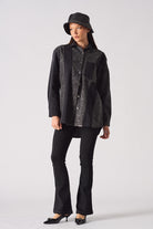 A model styled in the acid wash denim shirt for women with a bucket hat.