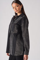 Angled side view of the women's acid wash jean shirt.