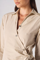 Close-up of the button detail on the women's asymmetric shirt dress.