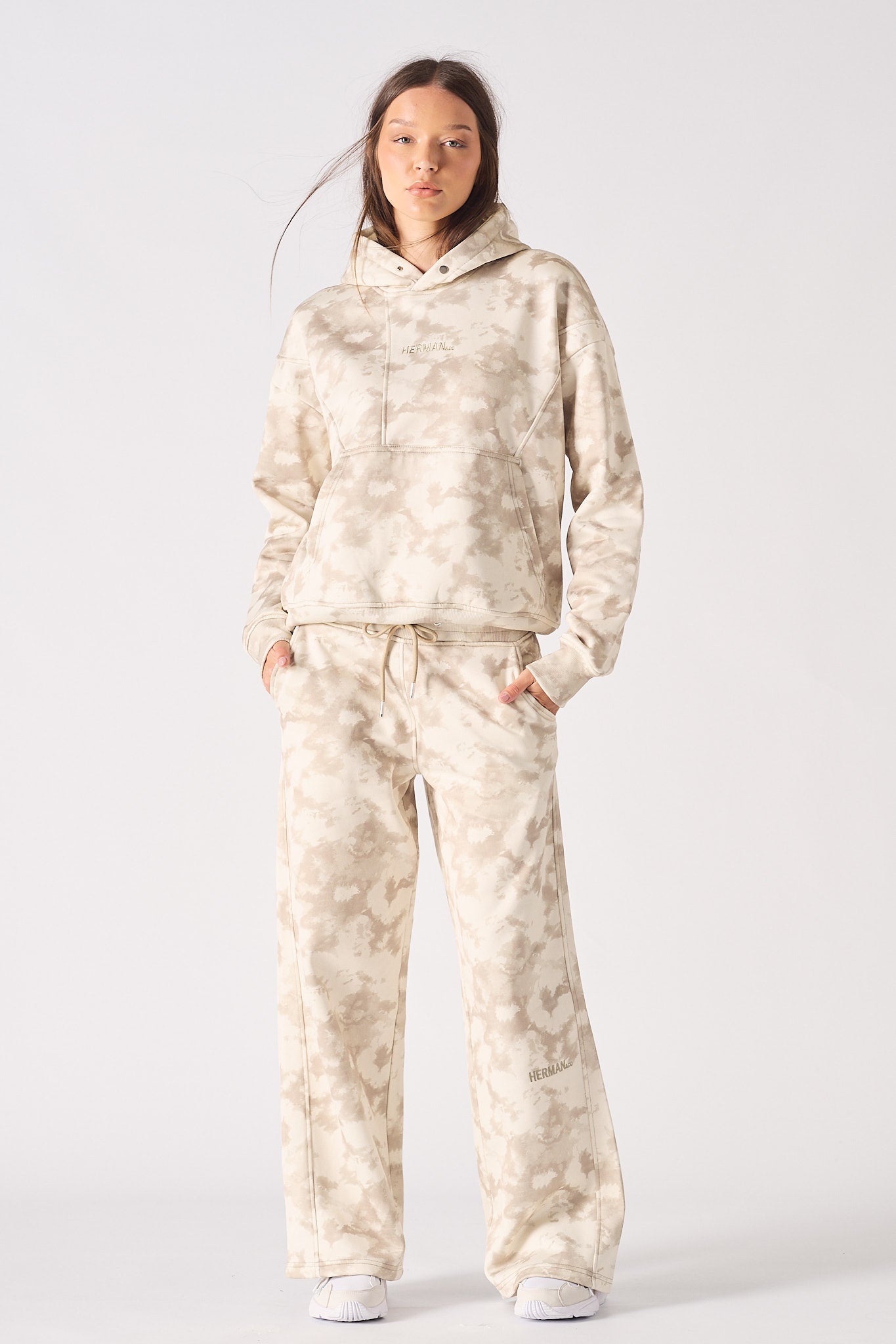 Mid section view of model showing the waistband fit of beige tie dye joggers