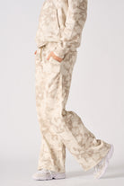 Close up side view of the pocket and wide leg fit on beige tie dye joggers