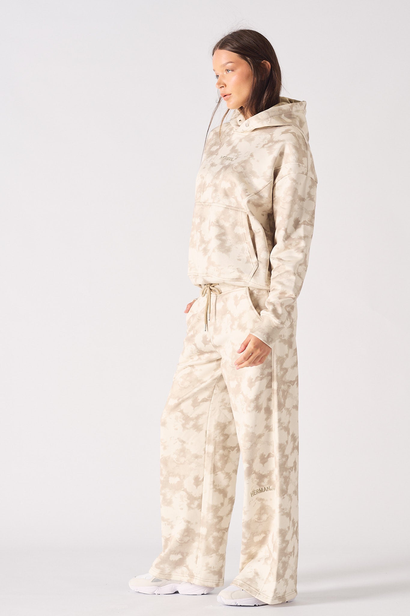 Rear view of model wearing beige tie dye wide leg joggers showing back fit