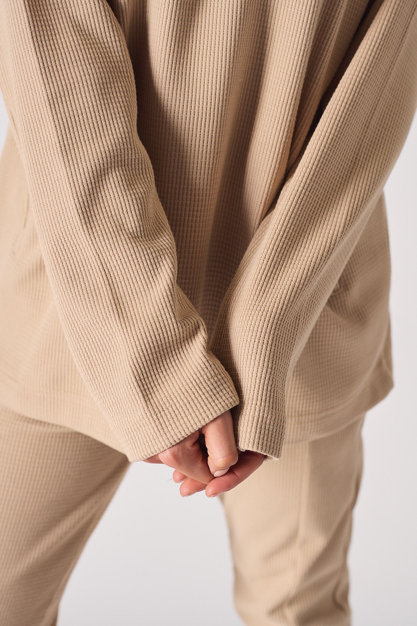 Side view showing the pocket detail on the oversized beige jumper