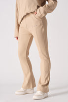 Side view of a model wearing beige waffle fit and flare joggers, showing the leg cut
