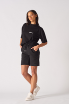 Model standing wearing black aline shorts womens with a relaxed fit