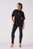 Full front view of a model in the women's black biker jeans.