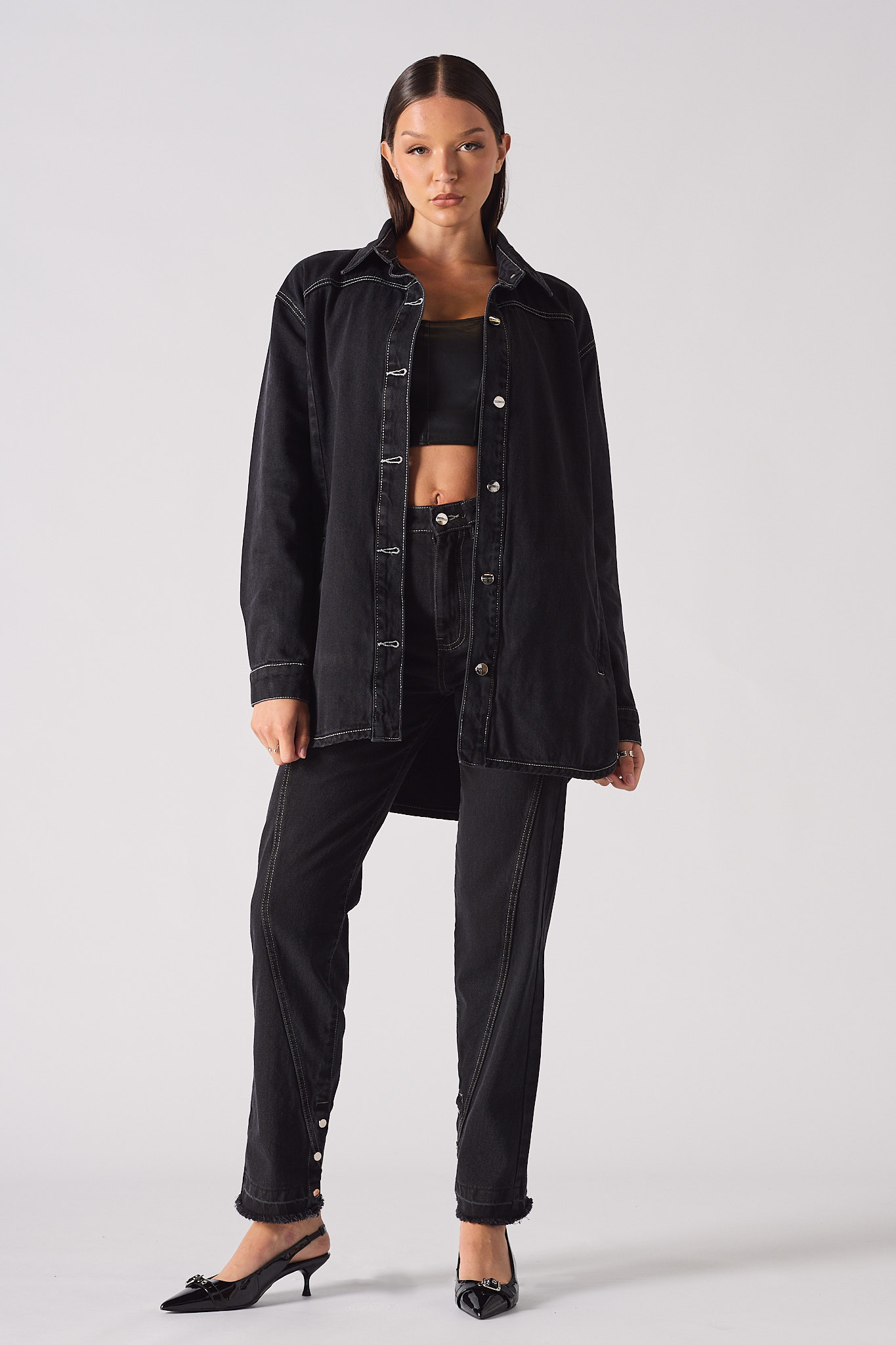 A model styled in the women's black contrast stitch denim shirt.