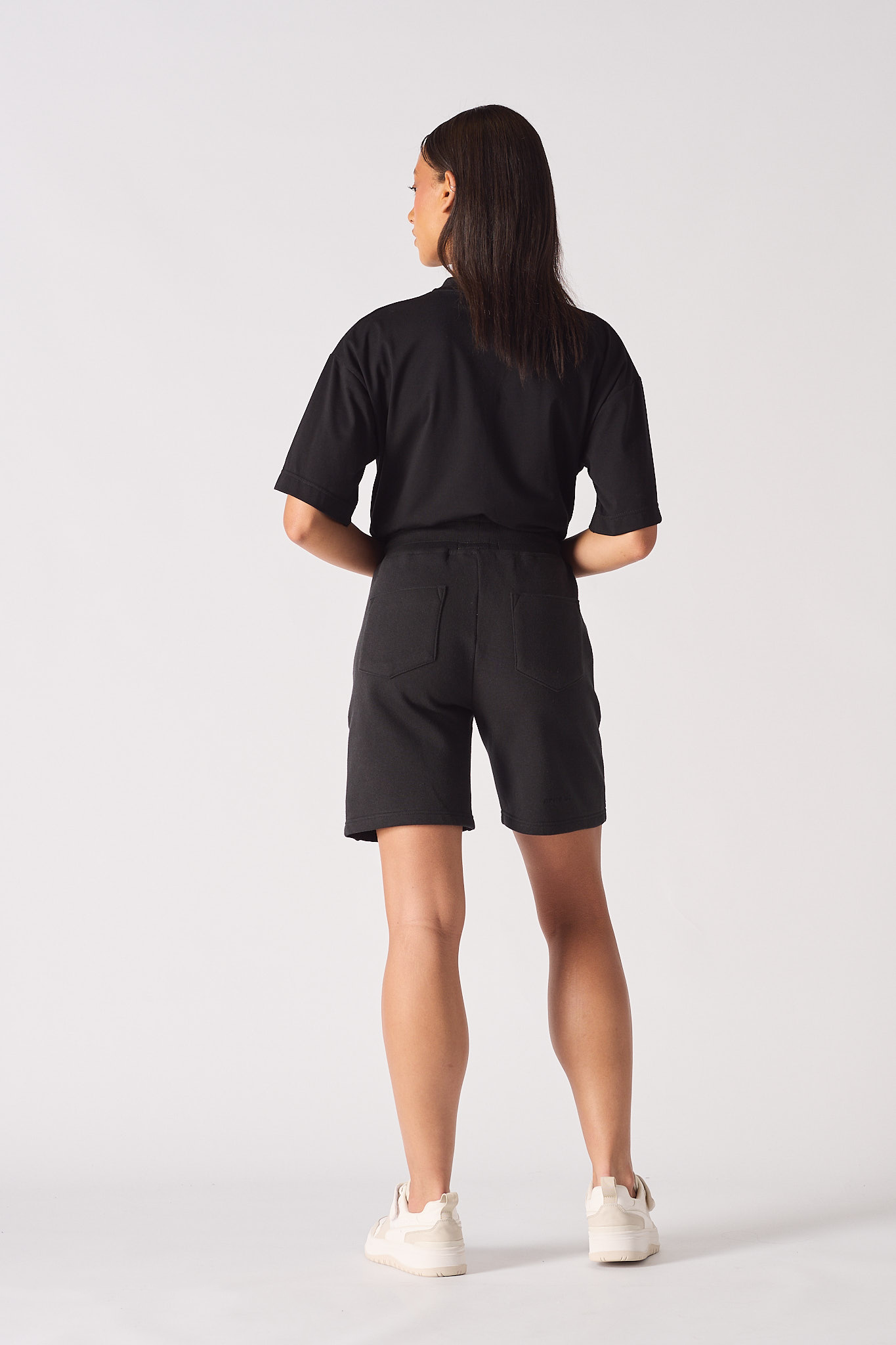 Rear view of model wearing comfortable black fleece shorts womens