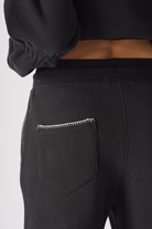 Close up of the elasticated waistband and drawstring on black contrast stitch jogger