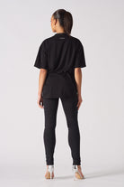 Back view of a model wearing the women's black skinny biker jeans.