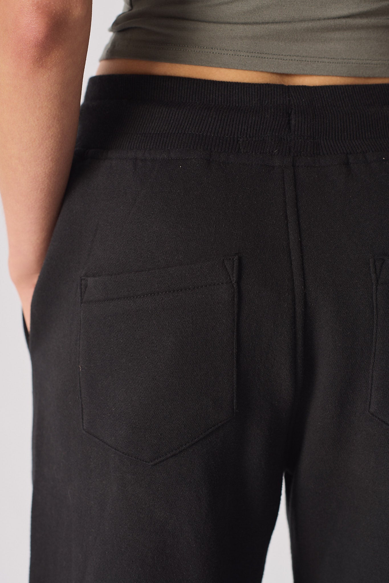 Detailed view of the back pocket on the black tapered joggers