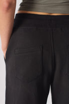Detailed view of the back pocket on the black tapered joggers