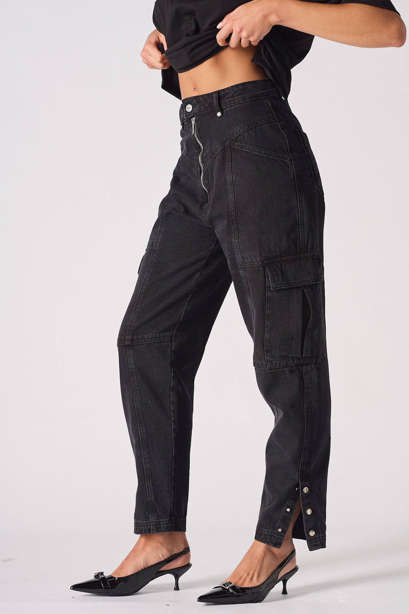 Side view of the black zip front jeans showing the popper hem detail.