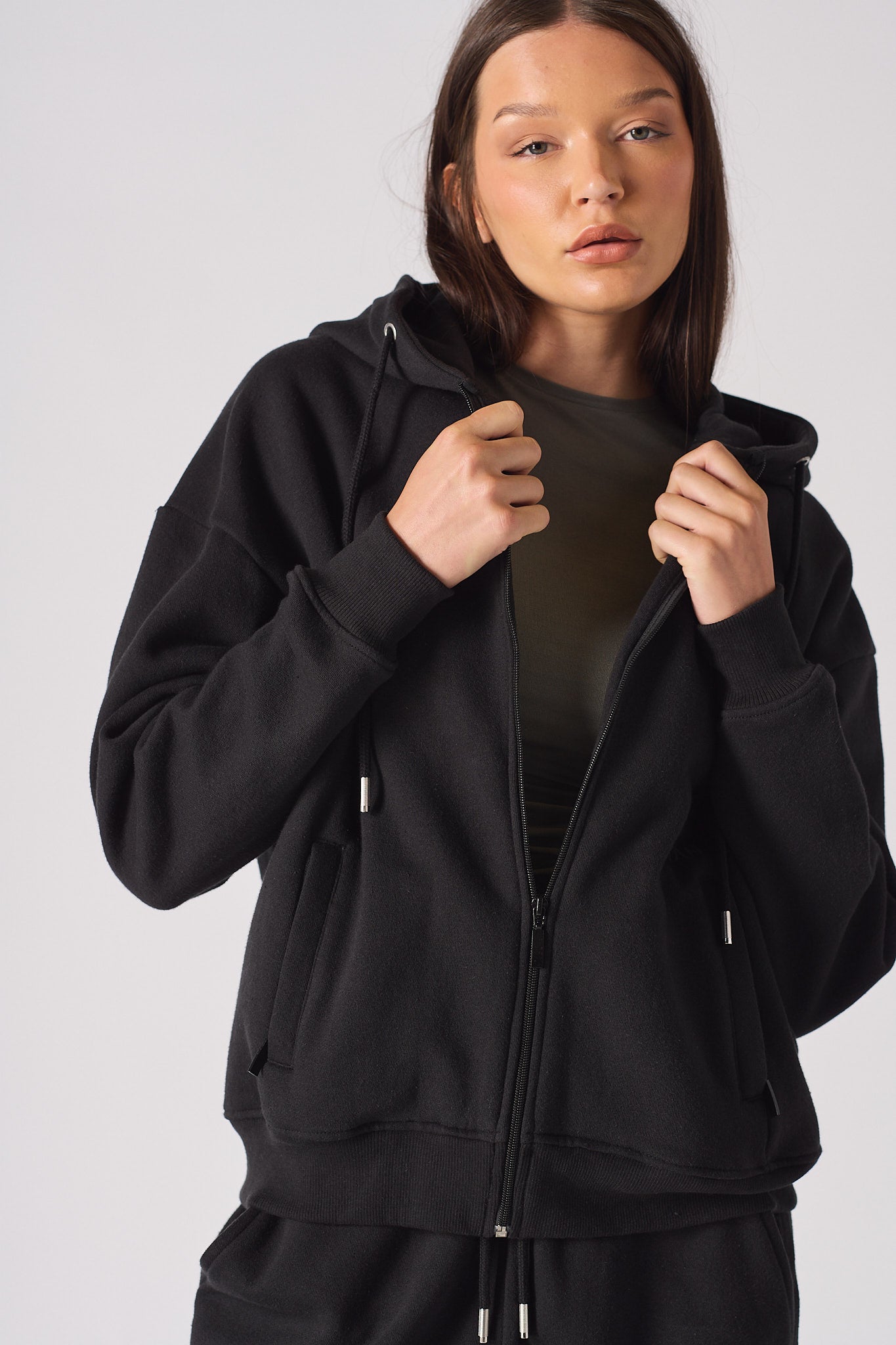 Side profile view showing the relaxed fit of womens black zip up hoodie