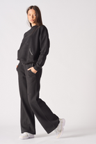 Side profile of a model walking in the women's blanket stitch jumper.