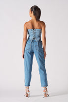Back view of a model in the women's blue cargo denim jeans and a matching top.