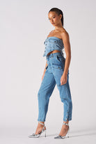 Side view of a model showing the fit of the blue cargo jeans for women.