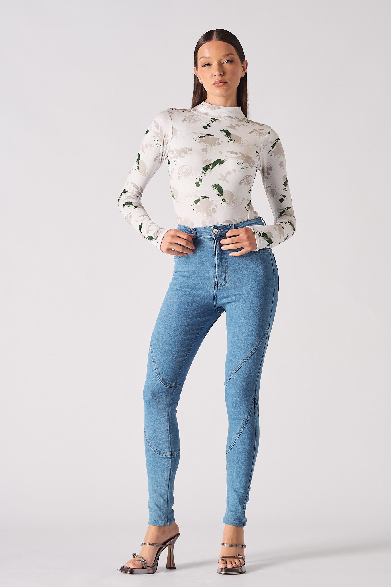 Full front view of a model wearing the blue skinny jeans in a high-waisted fit.