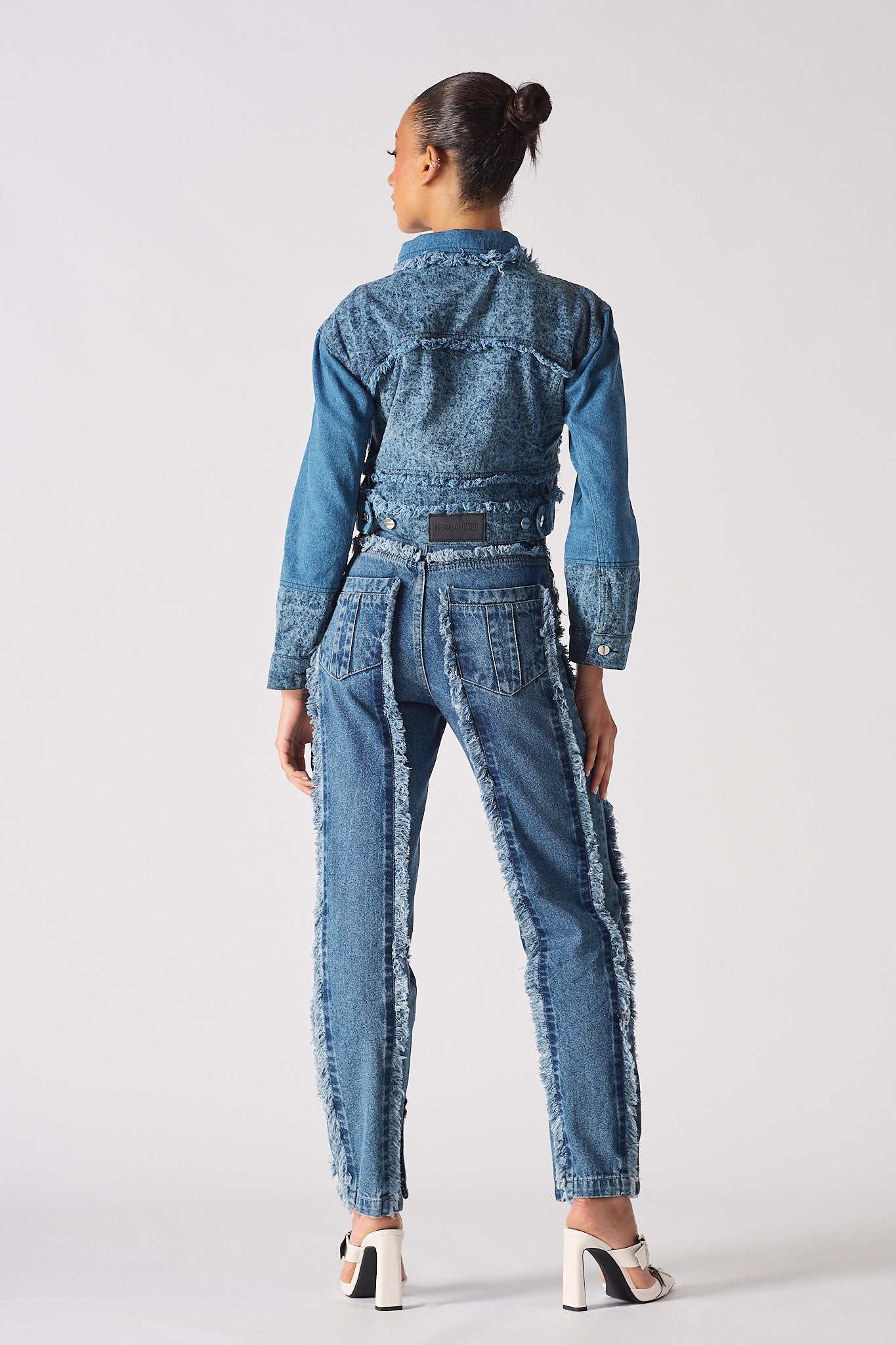 Back view of a model wearing the blue two-tone denim jacket.