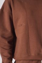 Close up texture view of the ribbed sleeve cuff on brown womens jumper