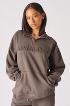 Close up view of the front pocket detail on womens brown half zip sweatshirt