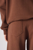 Detailed view of the back pocket on the brown joggers for women.