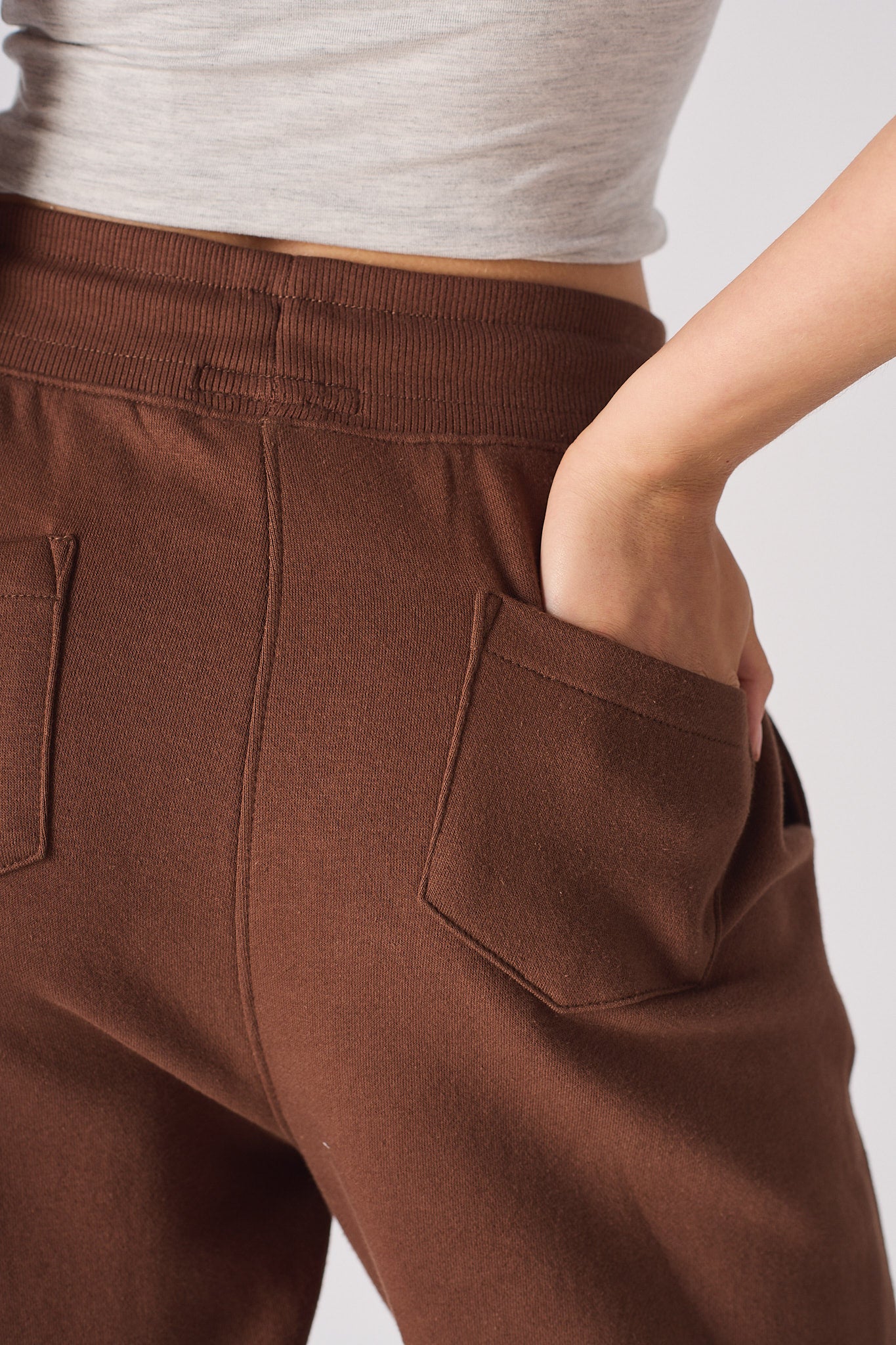 Close-up of the back pocket detail on the brown tapered joggers.