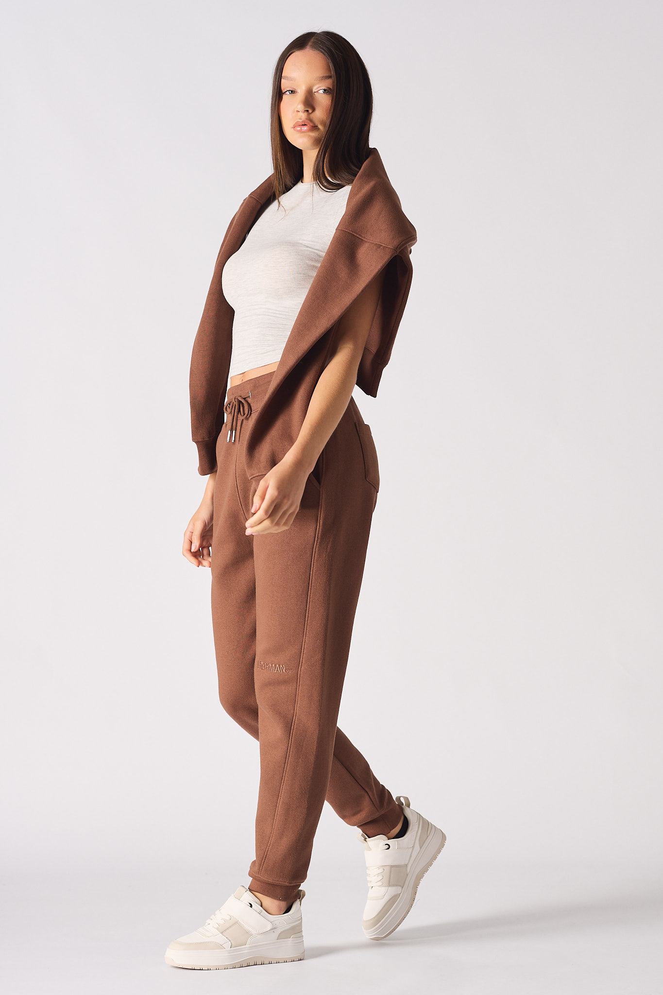 A model walking in the brown tapered joggers for women.