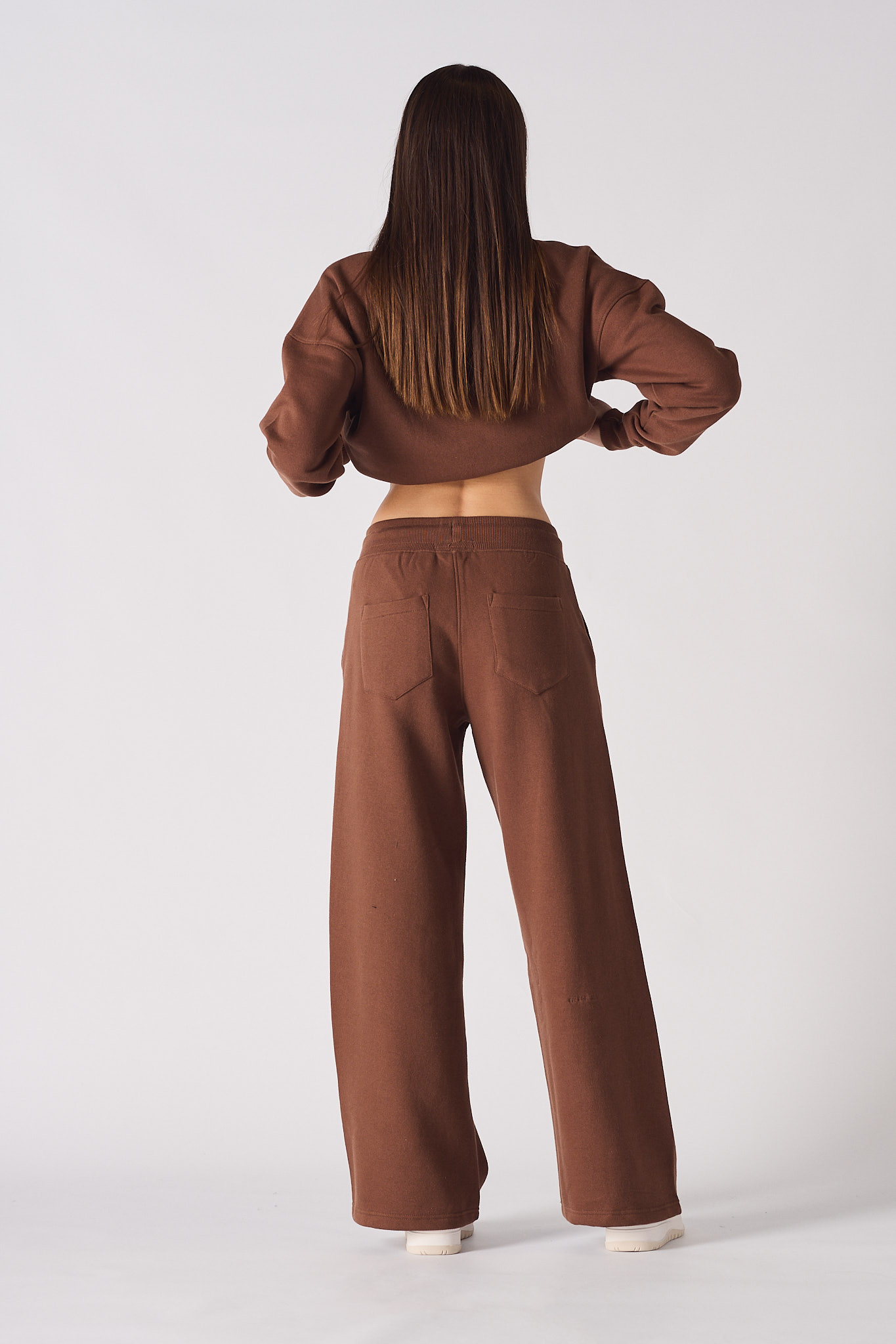 Back view of a model wearing the brown wide-leg joggers for women.