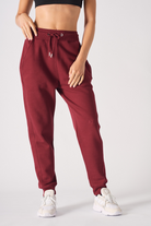 Close up detail of the elasticated waist and drawstring on burgundy joggers