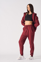 Side profile view showing the slim fit of womens burgundy tapered joggers