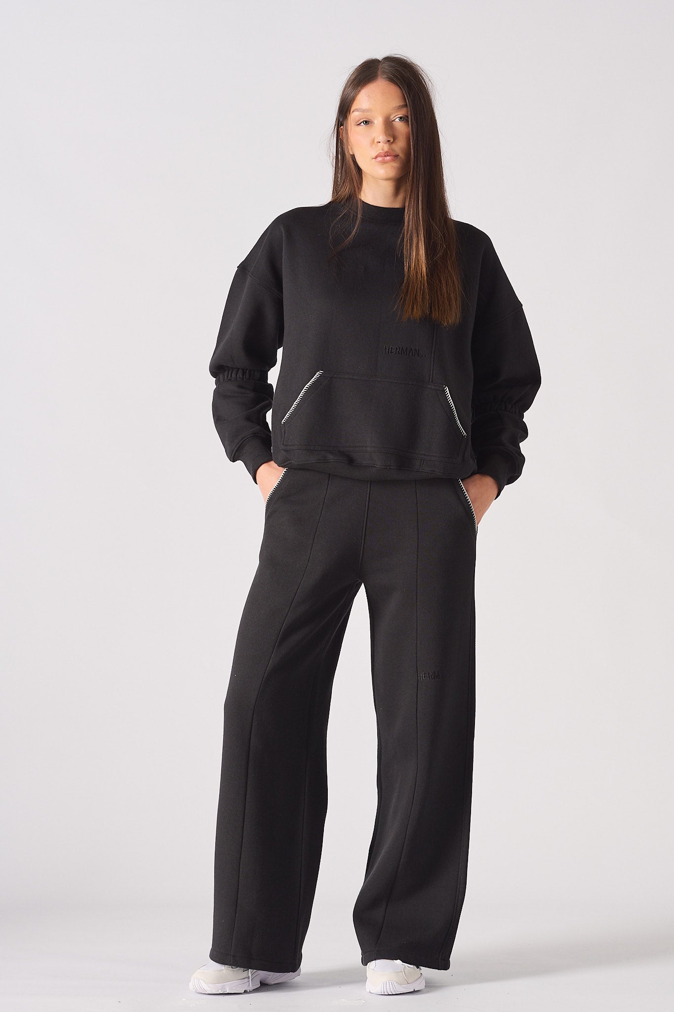 Detailed close up of the back pocket with white contrast stitching on black joggers