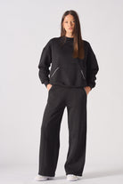 Detailed close up of the back pocket with white contrast stitching on black joggers