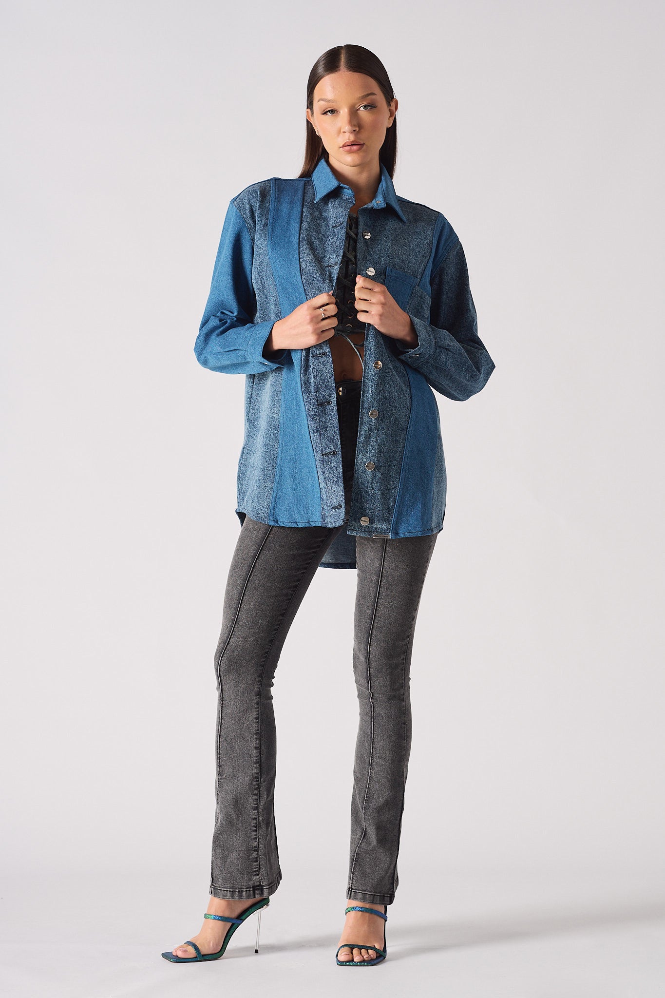 Side profile of the women's contrast wash denim shirt showing its length.