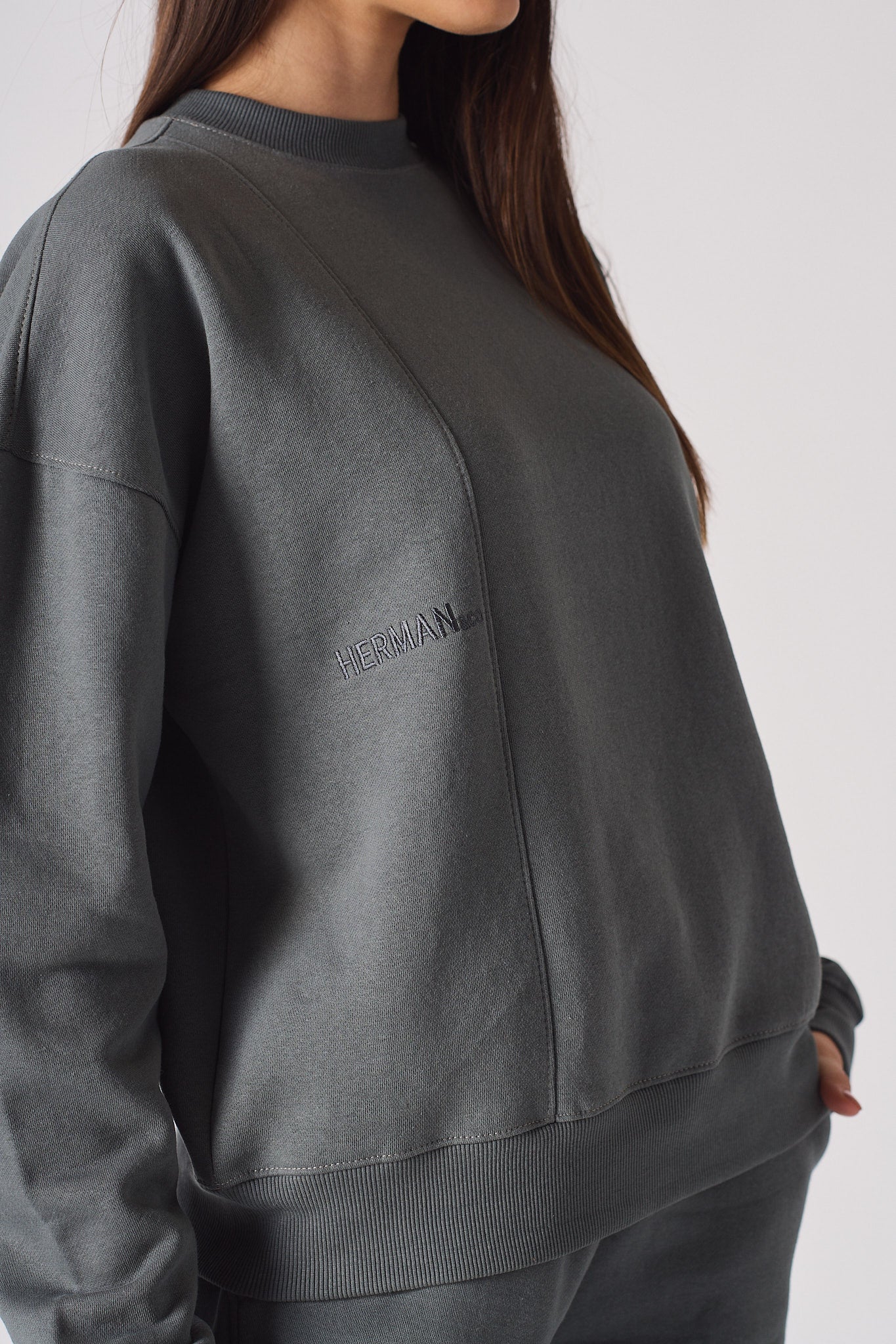 Detailed view of the ribbed sleeve cuffs on women's grey sweater